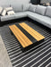 Black and Natural Striped Graphite Rug top view of rug with outdoor coffee table on top