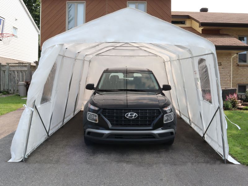 Gazebo Penguin Carport in White and Clear front view of white model with open front door and vehicle inside