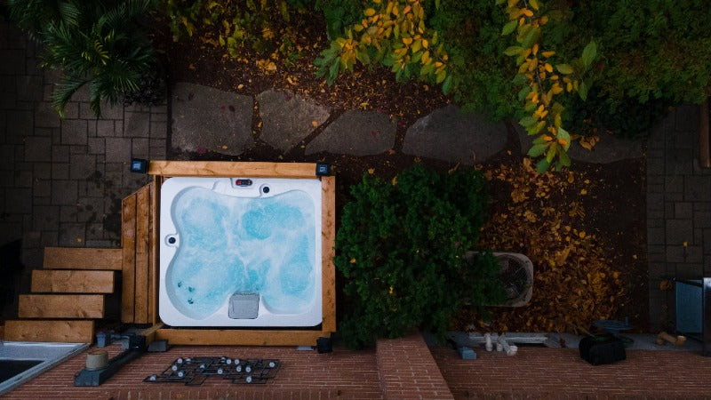 Canadian Spa Company - Manitoba 4-Person 15-Jet Portable Hot Tub top view of tub with water inside outdoors in a backyard