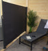 Corriveau Outdoor Furniture Retractable Side Awning 4.5'x10' view of awning open next to outdoor lounge chair for privacy