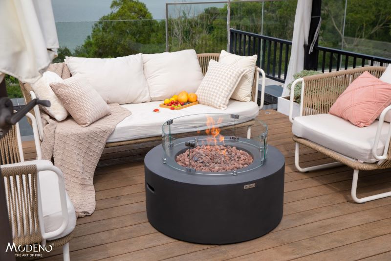 Backyard Lifestyles Modeno - Venice Fire Table front view of fire table with fire on a deck with patio furniture