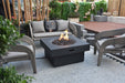 Backyard Lifestyles Modeno - Branford Fire Table in Black front view of fire table on deck with flame surrounded by patio furniture