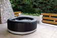 Backyard Lifestyles Aqua Marina MSpa - CAMARO 6 Premium Series Bubble Spa - Round front angle view with water outdoors